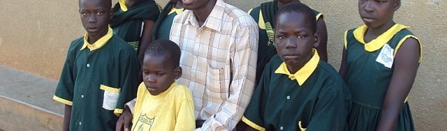 Pupils take photo with director on arrival at Fountain Primary School